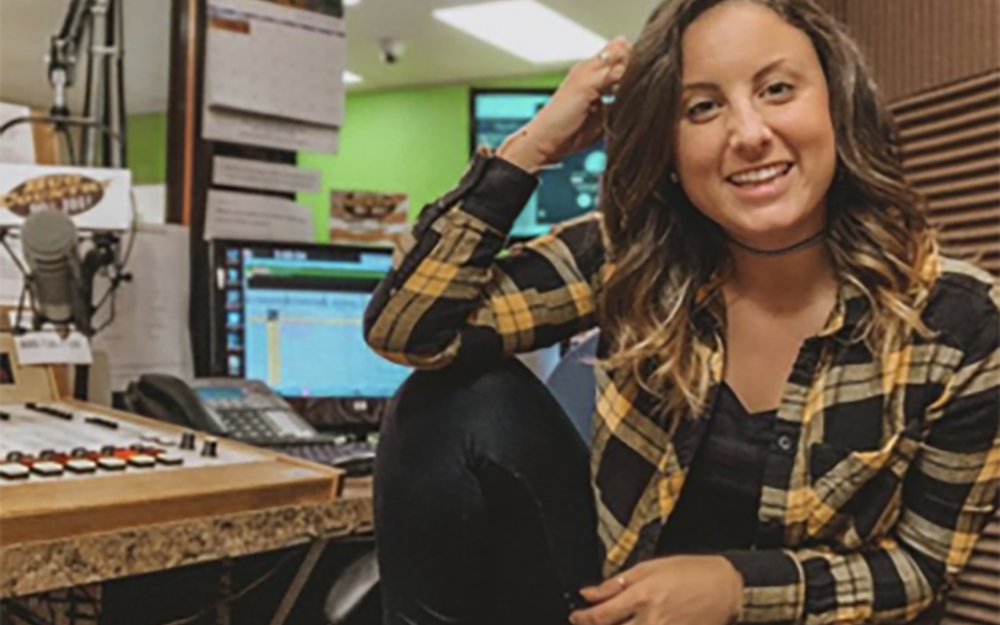 photo of Alexandria Dodge in her office in front of recording equipment