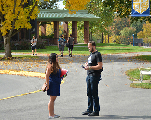 Two students talking in front of the library on SUNY Poly's Utica campus