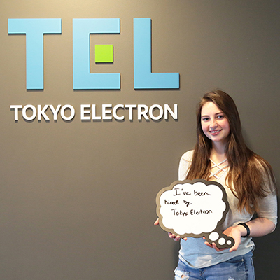 Student standing in front of Tokyo Electron sign
