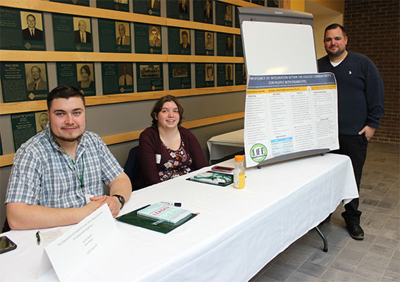 Presenters posing for photo with presentation