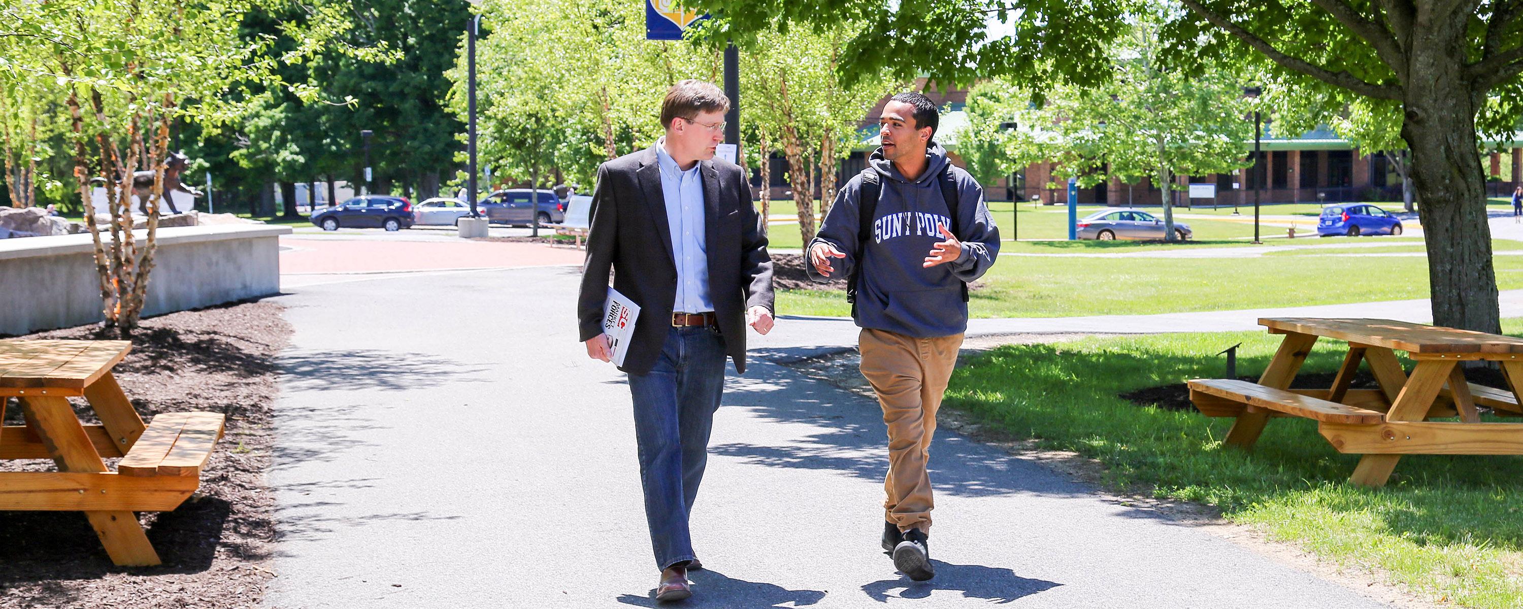 Student and Professor walking on Utica Campus