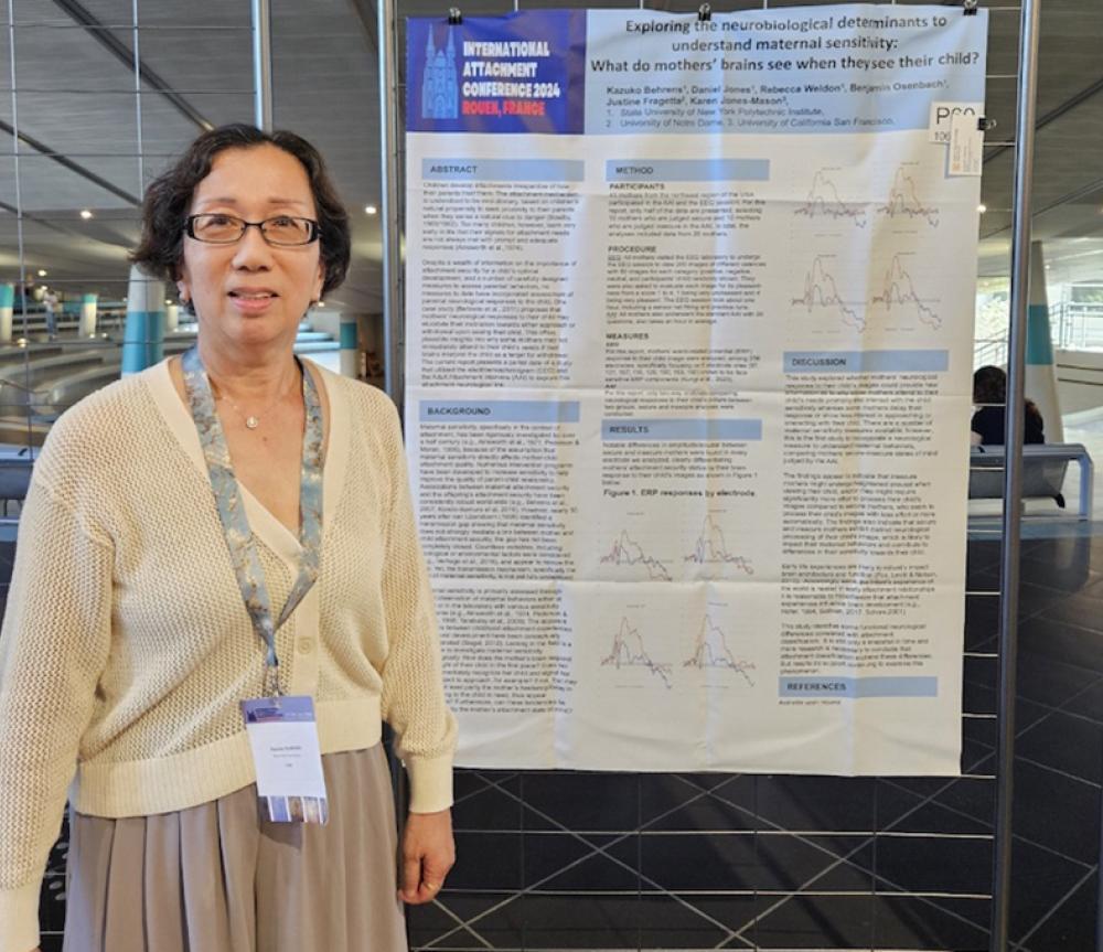 Dr. Behrens in front of a past research poster