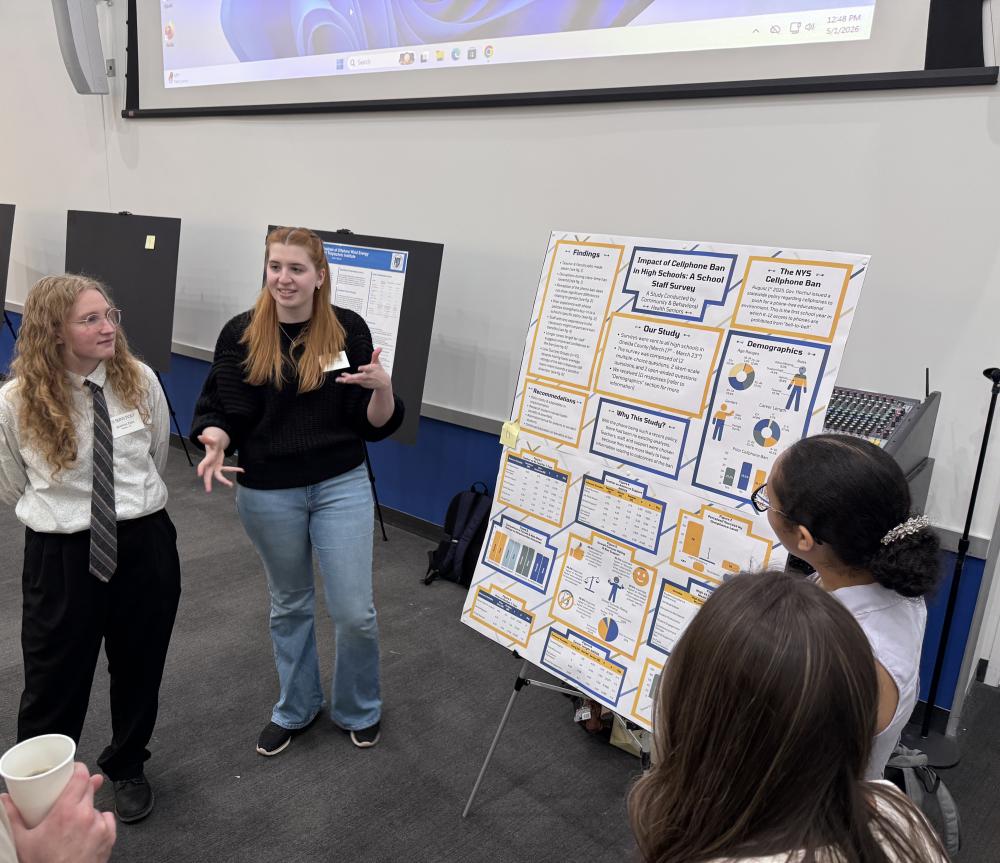 SUNY Poly students in front of a research poster explaining the study they did on NYS Cell phone ban in schools.