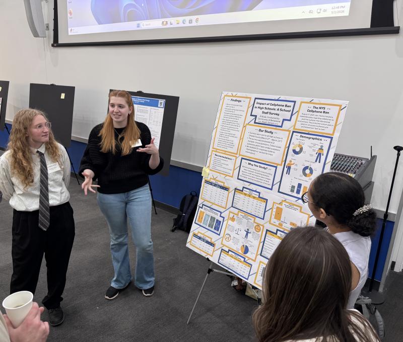 SUNY Poly students in front of a research poster explaining the study they did on NYS Cell phone ban in schools.
