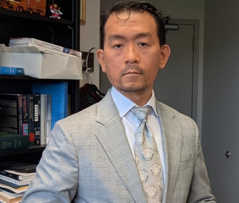 Dr. Yeh in a suit jacket, shirt and tie