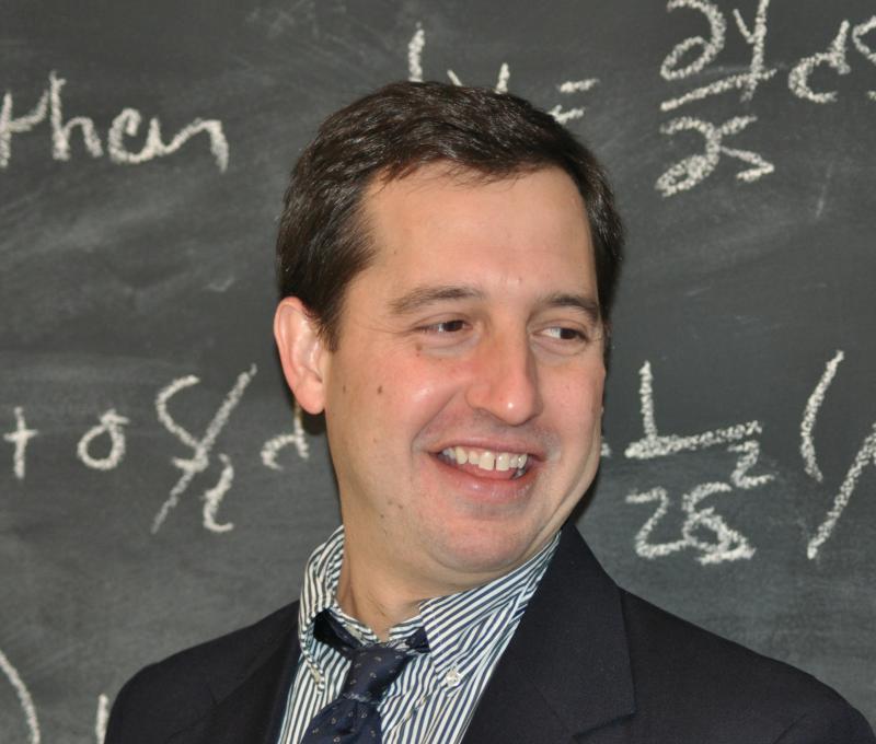 Dr Brigida in front of a chalkboard